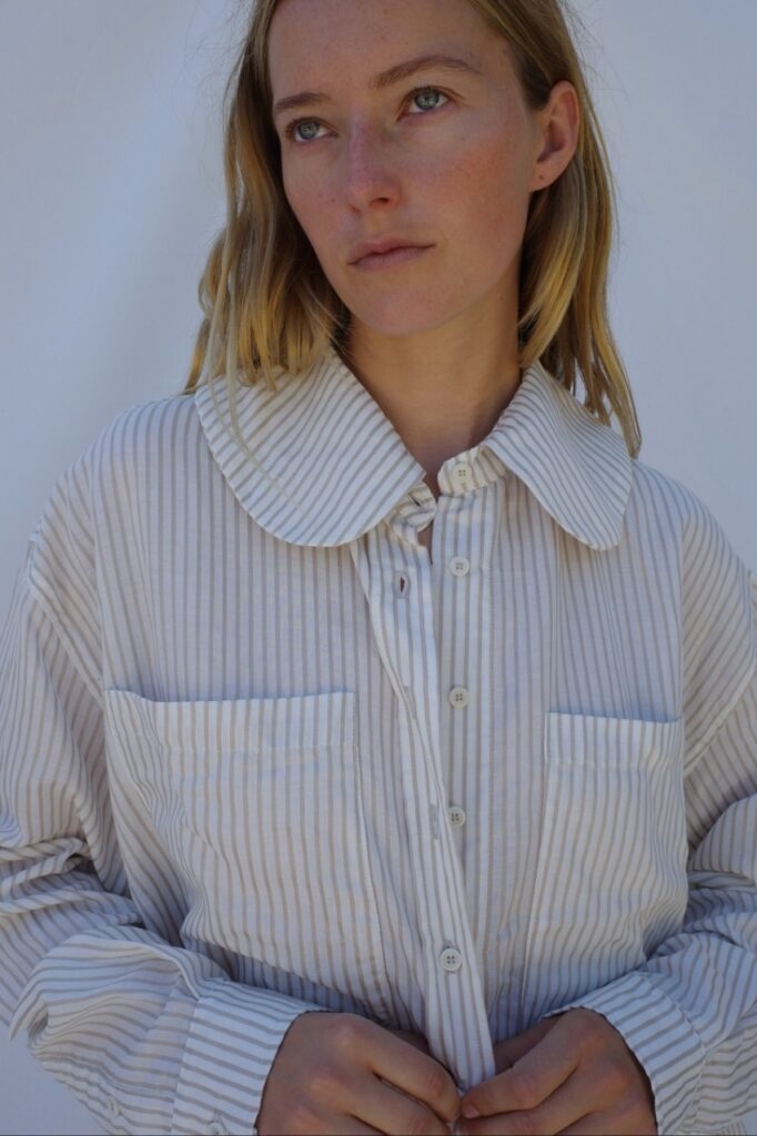 A woman in a white corduroy jacket with a big collar.